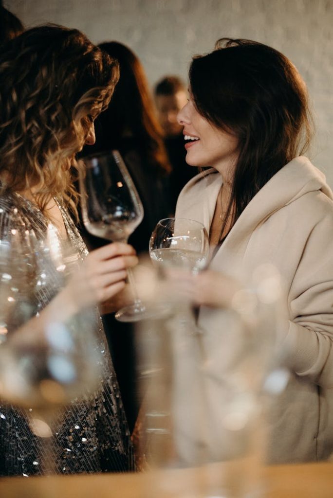 selective-focus-photography-of-talking-women-holding-wine-glasses-3171765 Two women enjoying a spirited conversation over wine at a lively gathering.